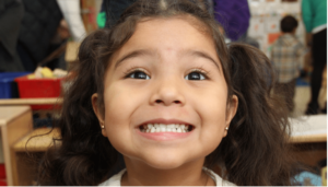 smiling girl with Cradles to Crayons