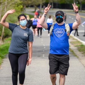 Masked walkers wave at camera